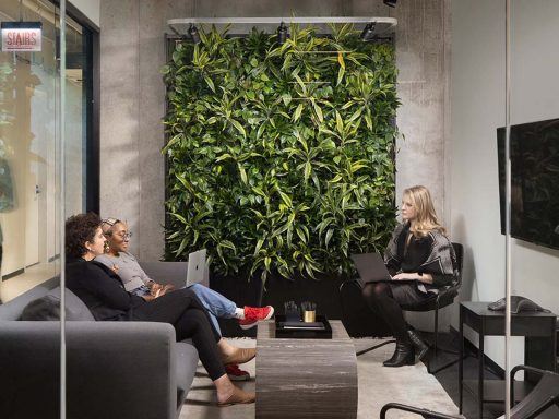 The Zauben Model Z living wall is an example of biophilic office design. Here, it's on display in the Zauben Showroom, in Industrious' Fulton Market location. The wall is a self-irrigating vertical structure covered top-to-bottom in greenery and is located in a stylish conference room with glass walls.